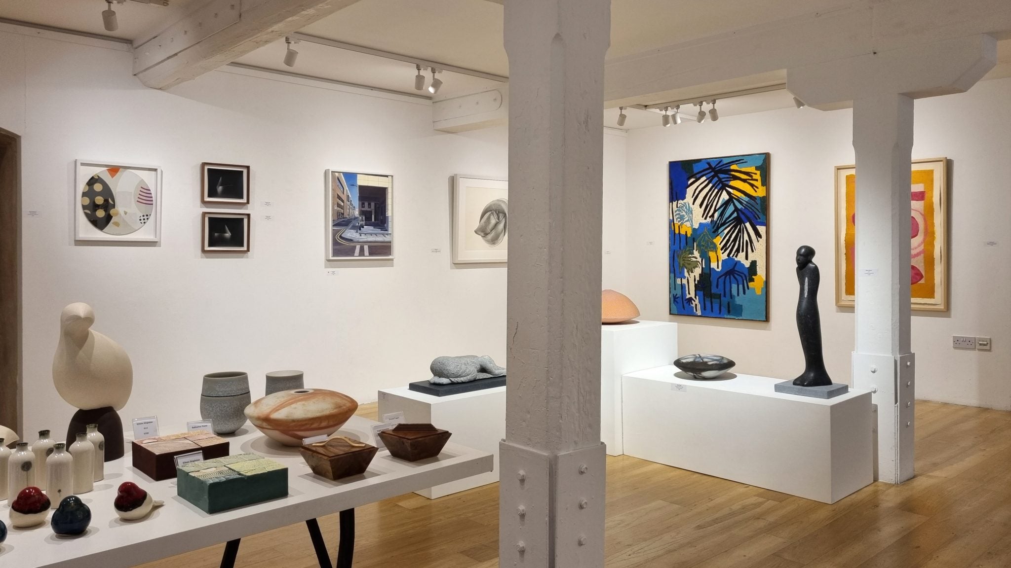 The interior of an art gallery with a selection of paintings, sculpture and pottery