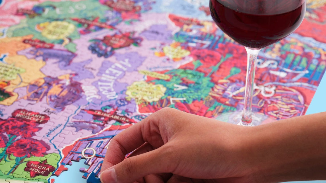jigsaw puzzle being solved next to a glass of red wine