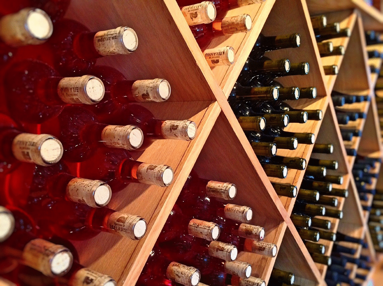 Wine bottles in racks - image by WOKANDAPIX from Pixabay