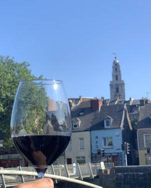 Glass of red wine with a view of Shandon in Cork in the background.